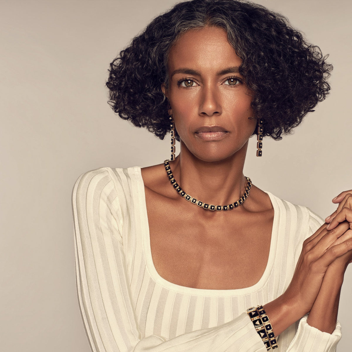 Model in a cream knit wearing the Nova Collar Necklace, Nova Stacker Drop Earrings and Nova Crystal Stacker Bracelet, photographed by Vijat M