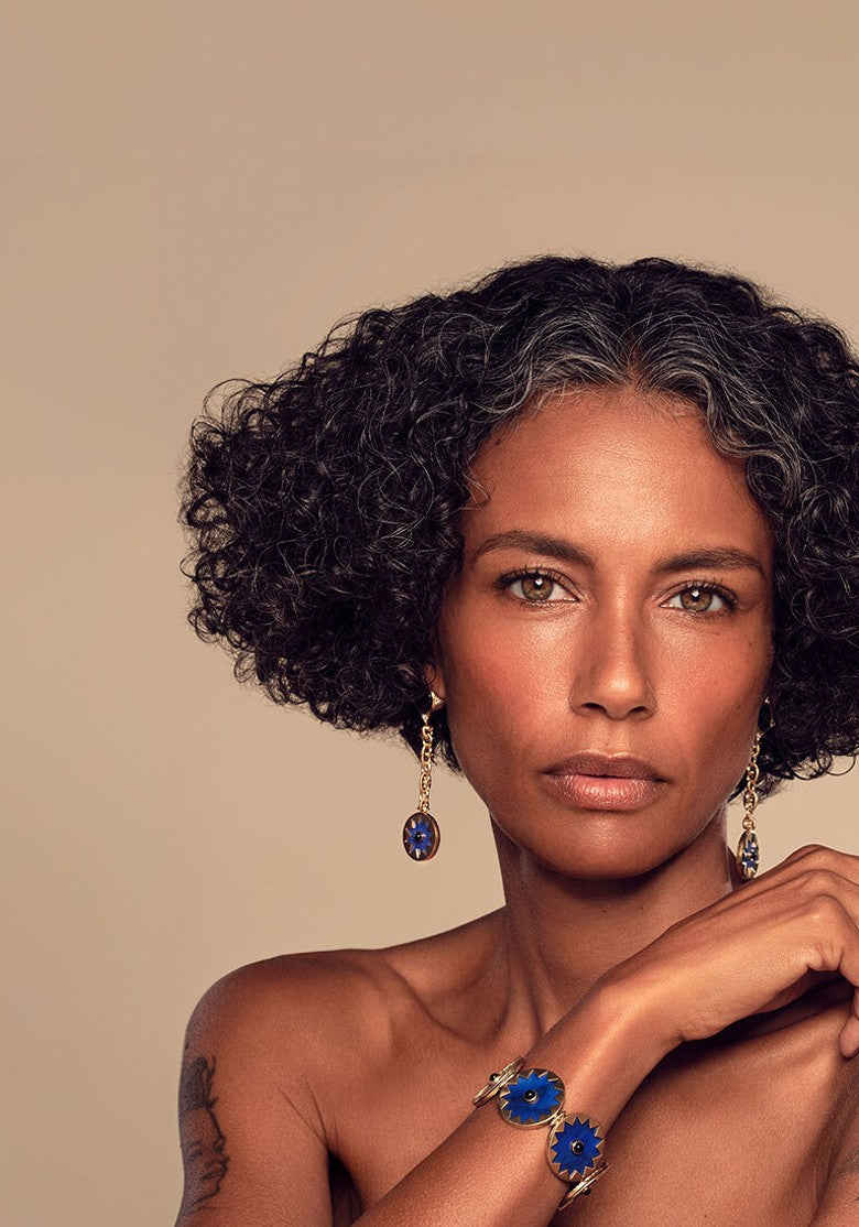 Sunburst Returns: model wearing the Sunburst Drop Earrings and Statement Bracelet in blue lapis