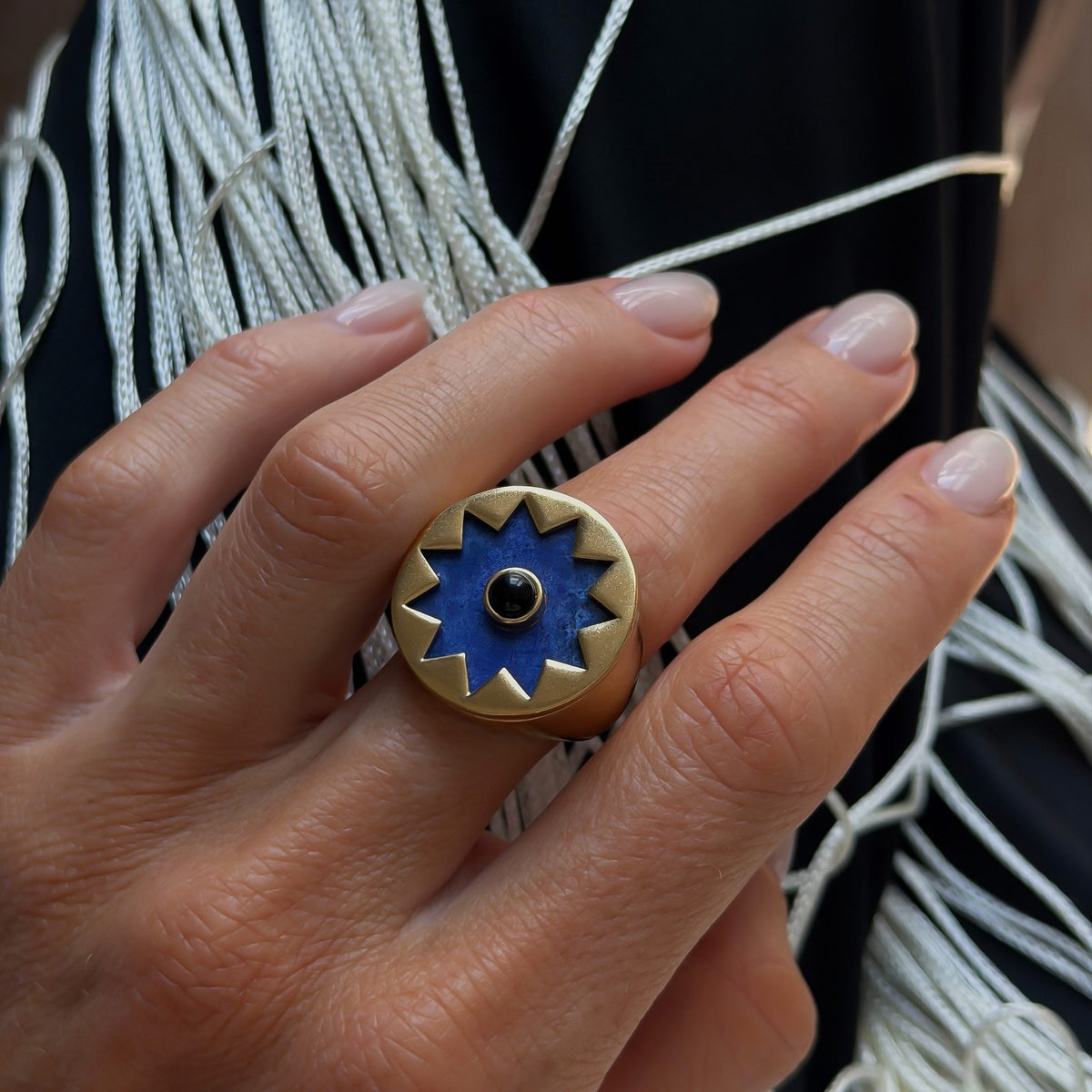 Close view of the Sunburst Signet Ring in blue lapis on the hand