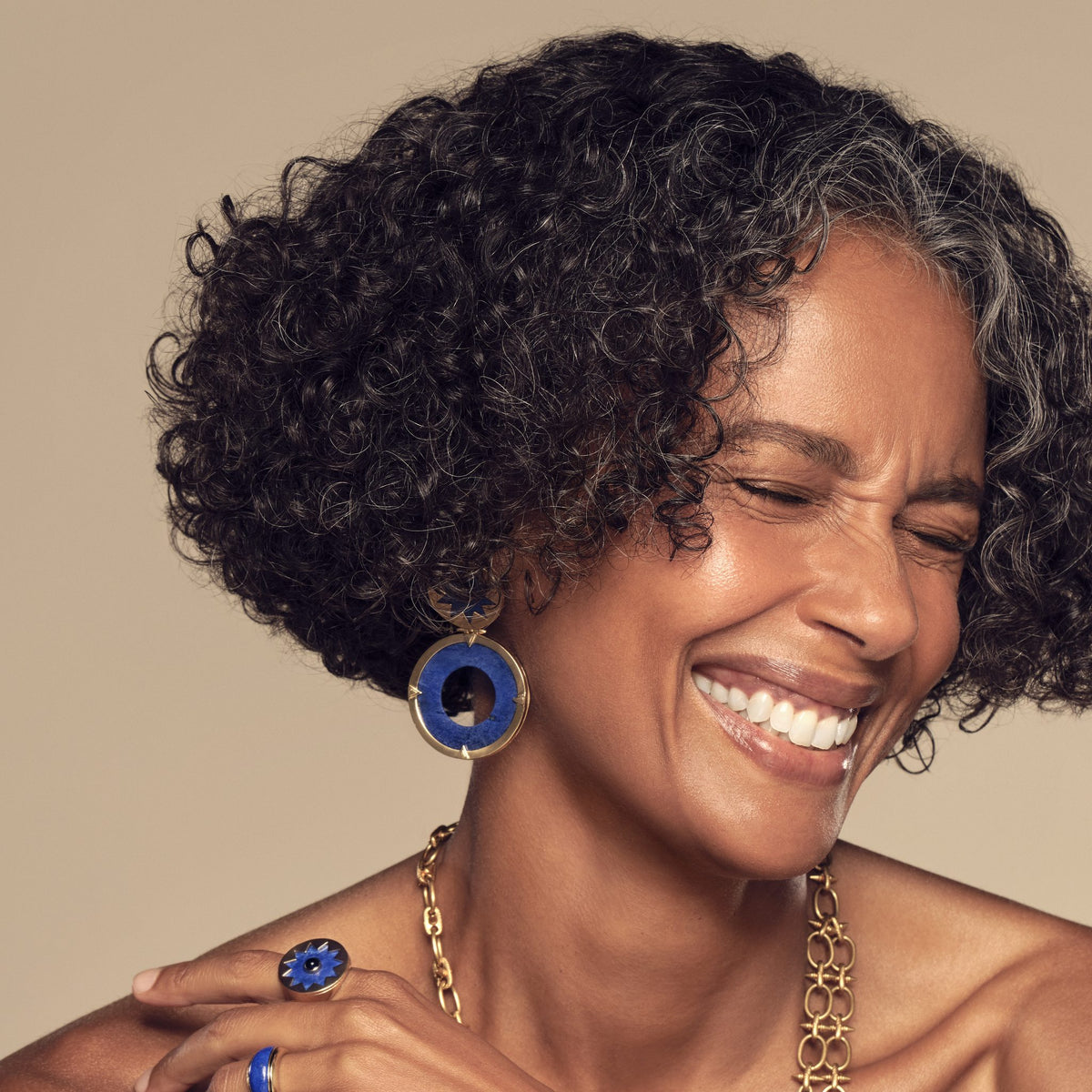 Model wearing the Sunburst Statement Earrings in blue lapis with the Sunburst Layering Necklace, Statement Bracelet and Cocktail Ring