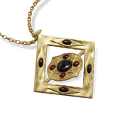 Close view of the Hathor pendant with its inner disc turned at an angle inside the gold frame, showing the onyx and red jasper setting