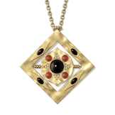 Close-up of the Hathor pendant with its inner disc turned inside the gold frame, showing the black onyx and red jasper setting