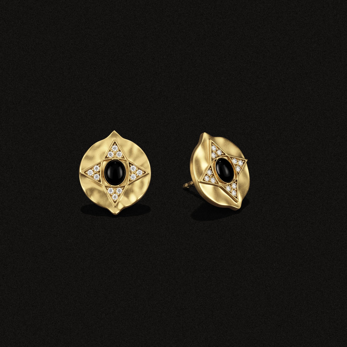 Hathor Stud Earrings in black onyx and 14k gold plate, three-quarter view on a black background