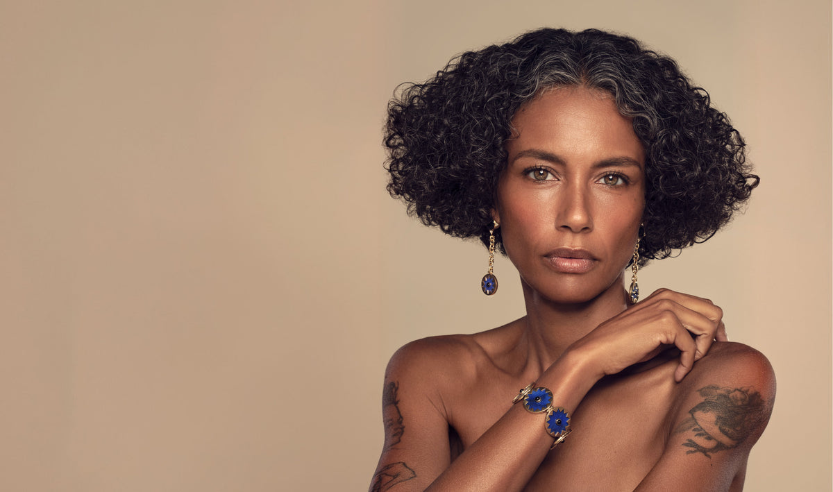 Sunburst Returns: model wearing the Sunburst Drop Earrings and Statement Bracelet in blue lapis