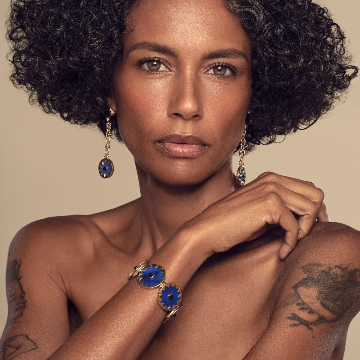 Model wearing the Sunburst Statement Bracelet in blue lapis with the Sunburst Drop Earrings #color_14k Gold Plated Sterling Silver